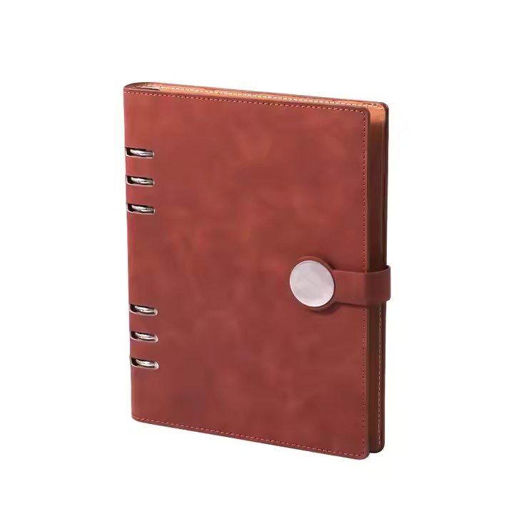 Brown notebook with a round clasp and decorative metal details