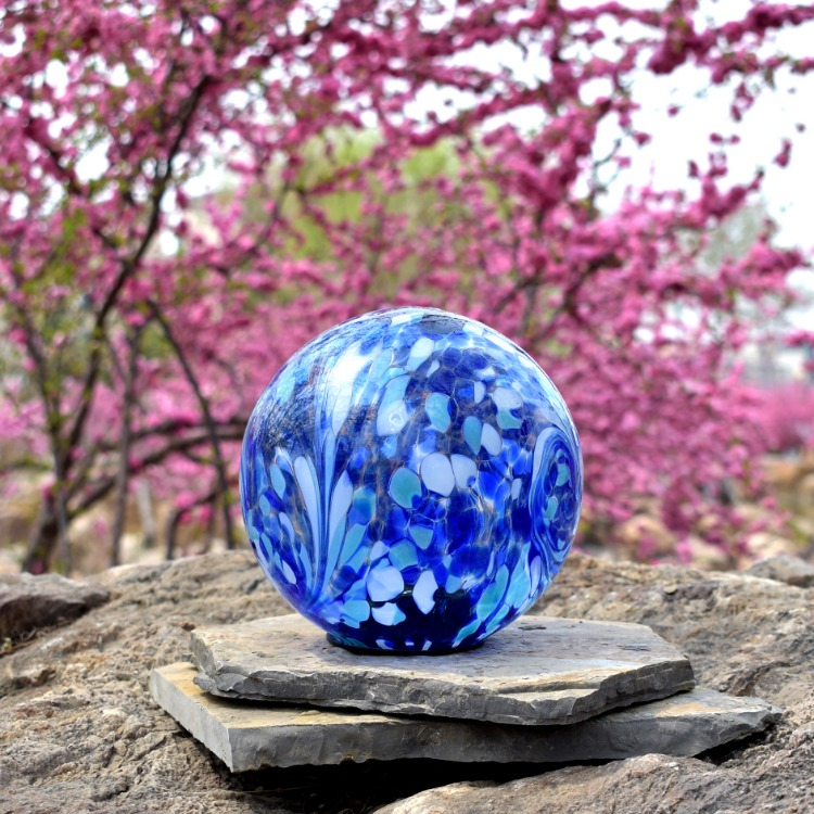 Blue-and-white patterned glass garden globe in an outdoor setting