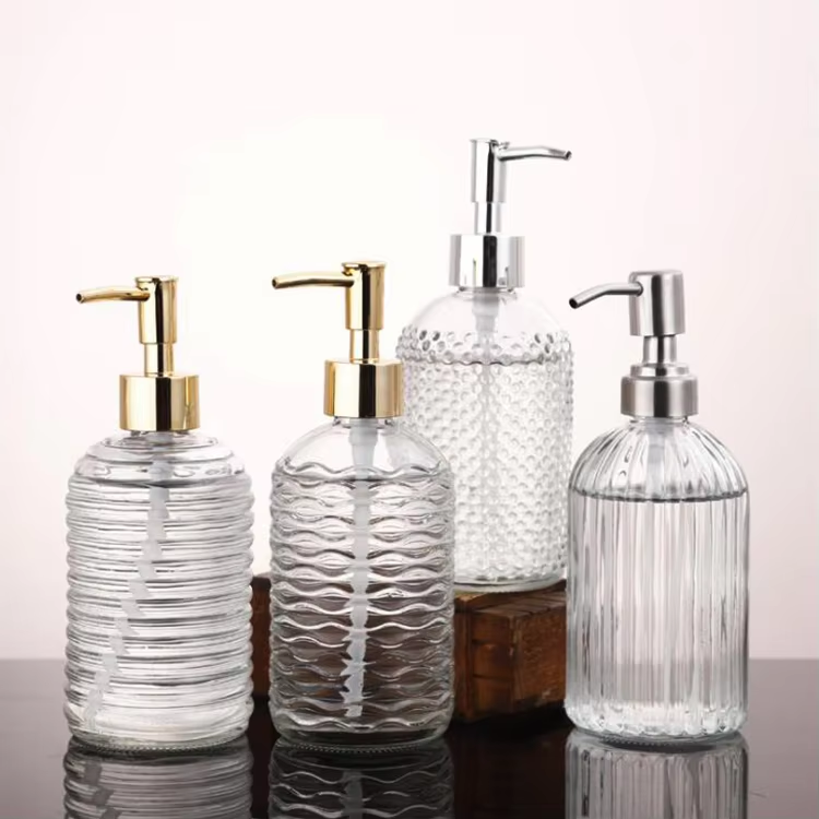 Four patterned clear glass pump bottles