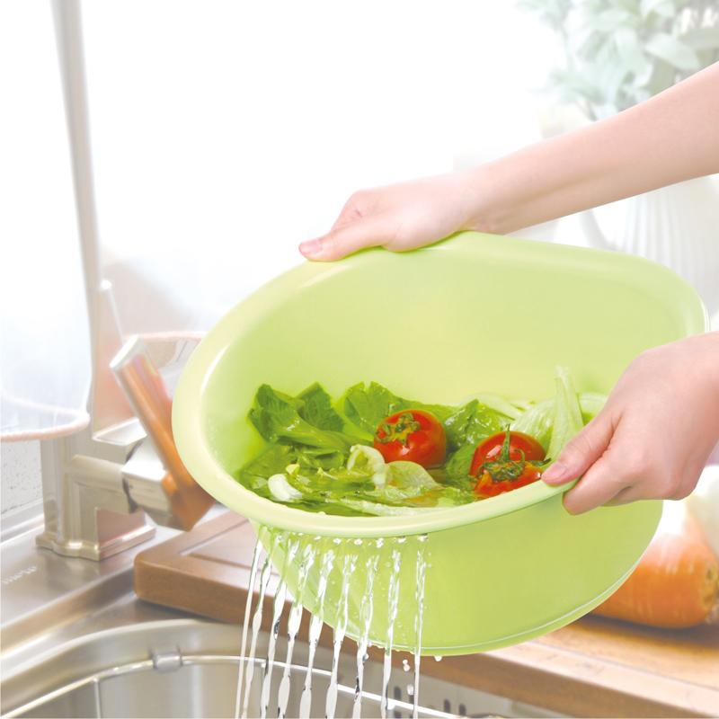Household basin draining vegetables at a sink
