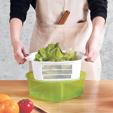 Inner sieve lifted from a bowl during vegetable rinsing
