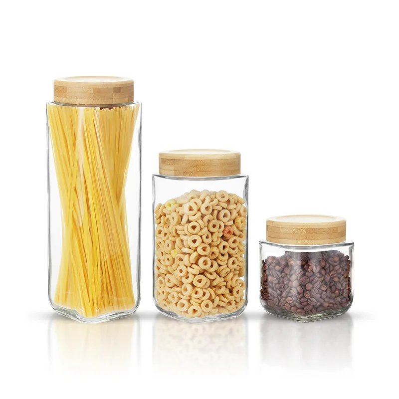 Three glass pantry jars with bamboo lids and display food contents